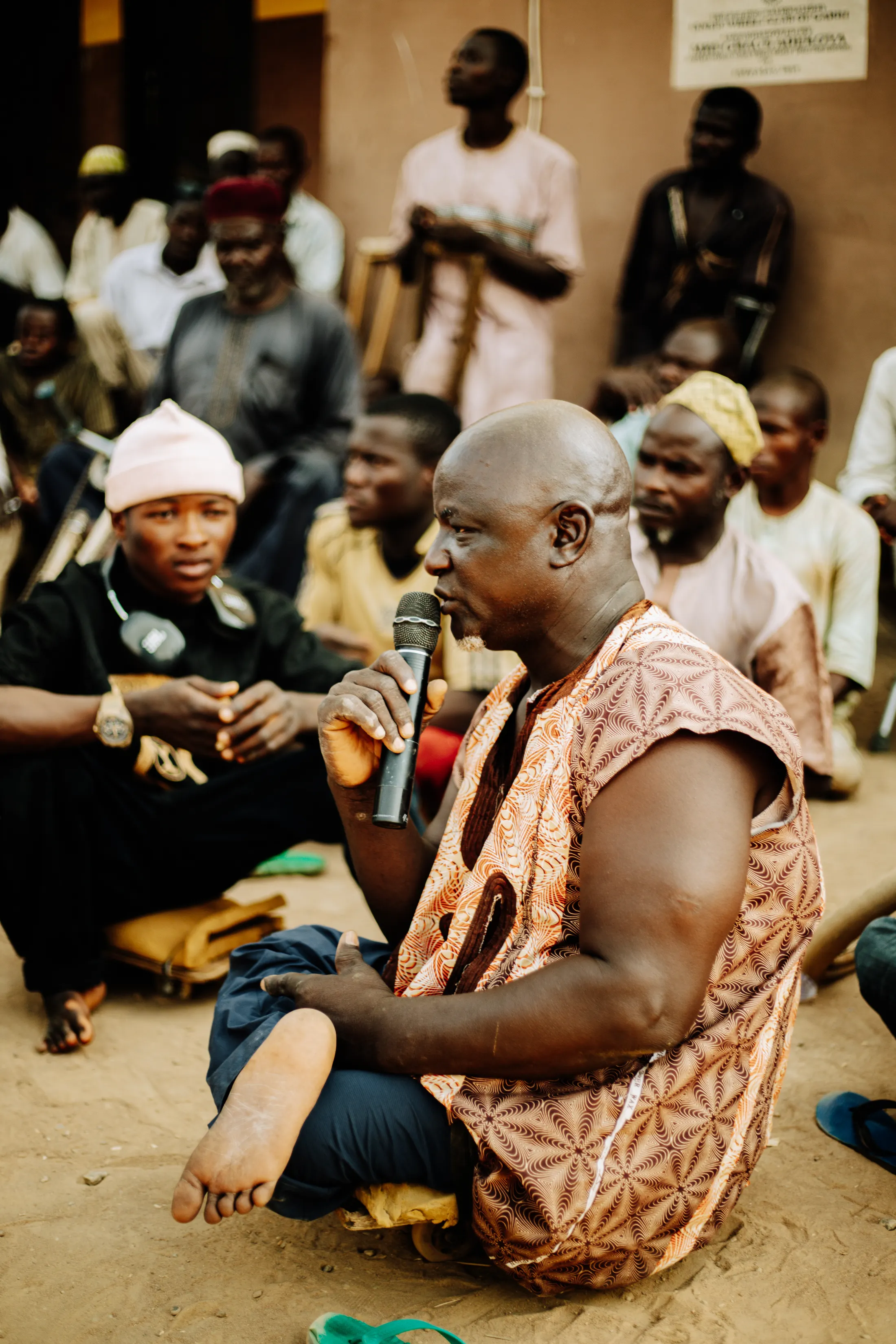 Illustrative stock photograph of an African community member speaking at a public gathering; this is not a CVID-CAM event